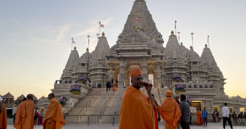 Monks in saffron robes walk in front of the BAPS Swaminarayan Akshardham temple on Wednesday in Robbinsville, New Jersey.