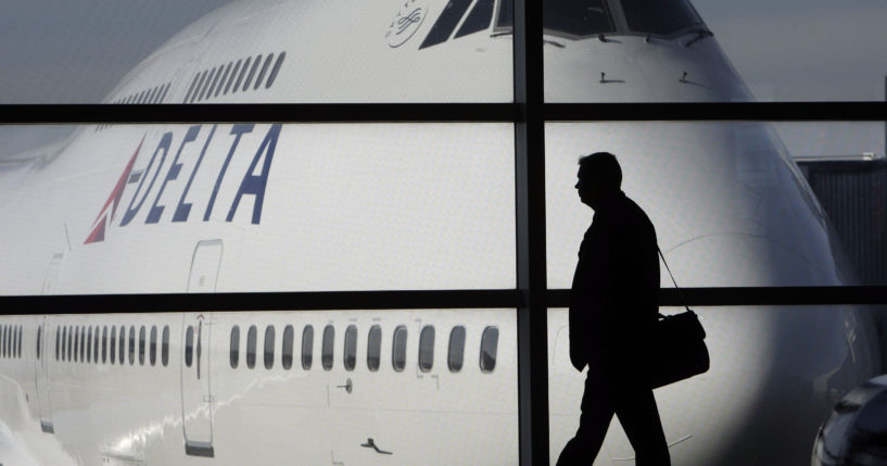 A passenger walks past a Delta Airlines 747 aircraft at Detroit Metropolitan Wayne county Airport in Romulus, Michigan, on Jan. 21, 2010. Several major airlines have announced they are cancelling flights in and out of Israel following the nation's declaration of war on Hamas.