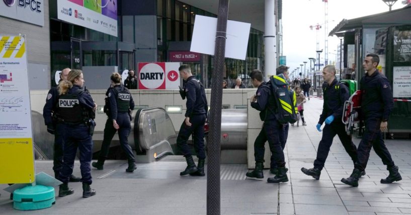 Police officers enter a subway station in Paris, France, on Tuesday, after a woman allegedly made threatening remarks on a train, resulting in police firing on the woman.