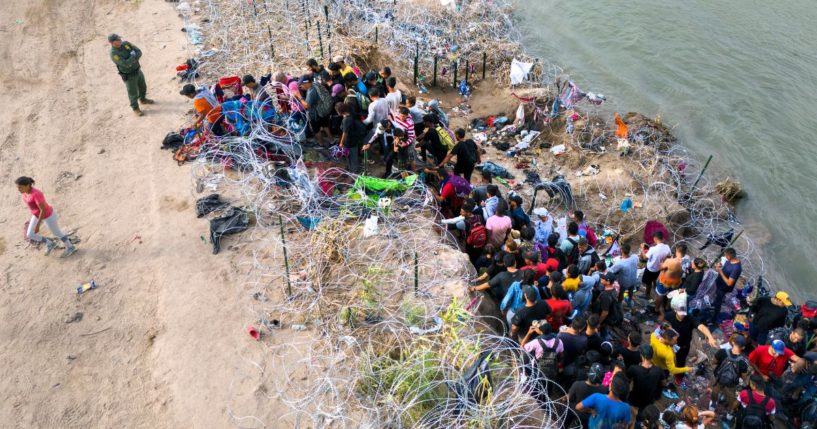 A U.S. Border Patrol agent supervises as immigrants walk into the United States after crossing the Rio Grande from Mexico on September 30 in Eagle Pass, Texas. GOP Sen. John Kennedy of Louisiana said eight million illegal immigrants have flooded the U.S. since President Joe Biden took office in 2021.