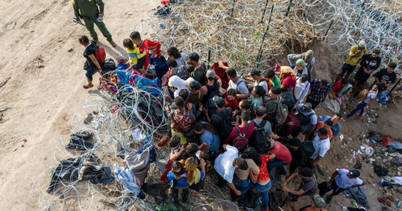 A U.S. Border Patrol agent supervises as illegal immigrants walk into the U.S. after crossing the Rio Grande from Mexico on Sept. 30 in Eagle Pass, Texas.