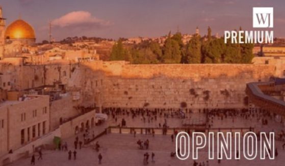 The Western Wall in Jerusalem with the dome of Temple Mount, left.