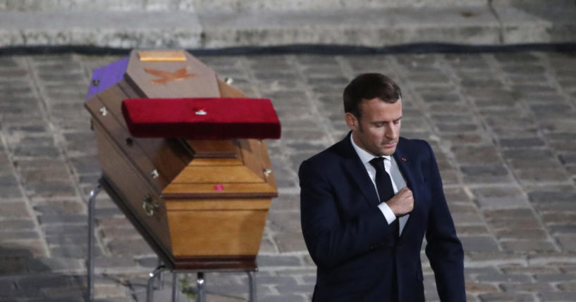 Emmanuel Macron paying respects near the coffin of a murdered French teacher