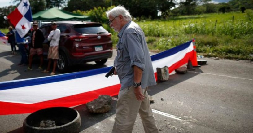 A man identified as 77-year-old Kenneth Darlington holds a gun during a confrontation with protesters blocking a road in Panama.