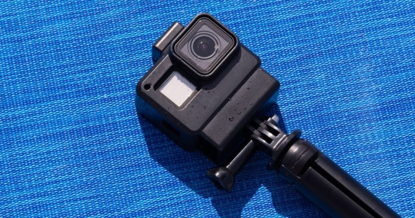 An action camera, like a GoPro, is pictured on a blue background. A family in Massachusetts made a gruesome discovery after they put a GoPro down a well and discovered the body of their missing family member.