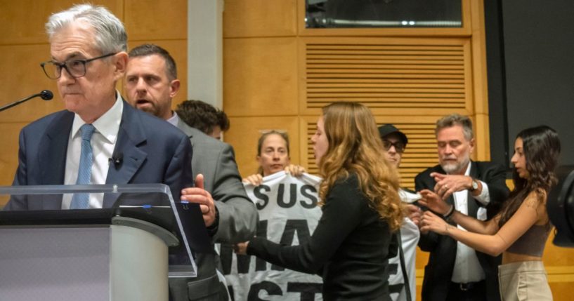 Jerome Powell being escorted off stage