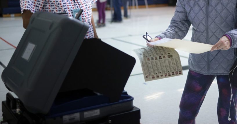 A voted in Ashburn, Virginia, prepares to submit her ballot on Tuesday.