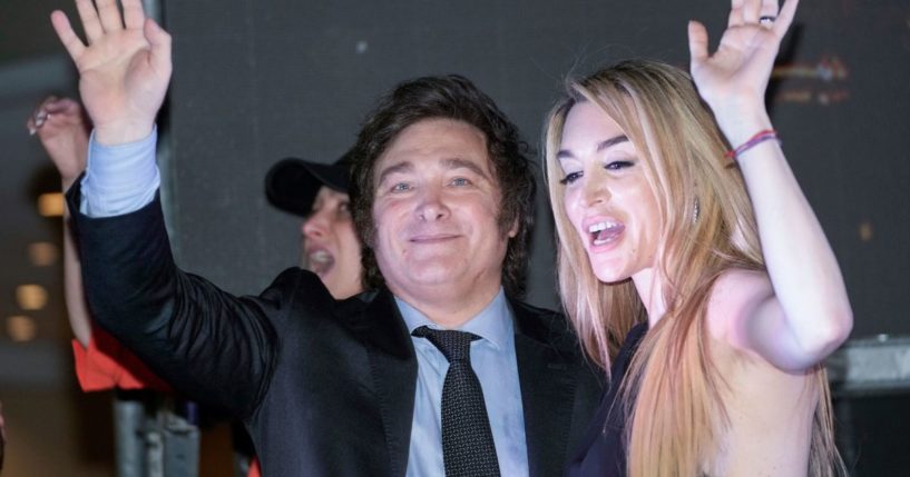 Presidential candidate of the Liberty Advances coalition Javier Milei, right, and his girlfriend Fatima Florez wave to supporters outside his campaign headquarters after winning the runoff election in Buenos Aires on Nov. 19.