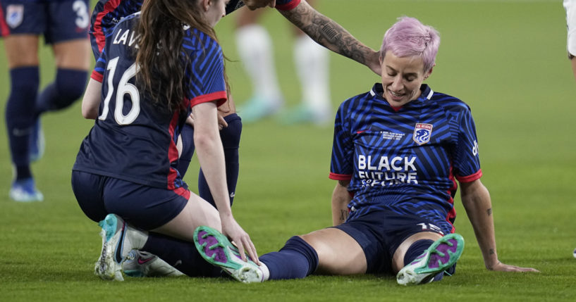 OL Reign forward Megan Rapinoe, right, stays down after an injury as teammates midfielder Rose Lavelle (16) and midfielder Jess Fishlock, center, check on her during the first half of the NWSL Championship soccer game against NJ/NY Gotham, Saturday, Nov. 11, 2023, in San Diego.