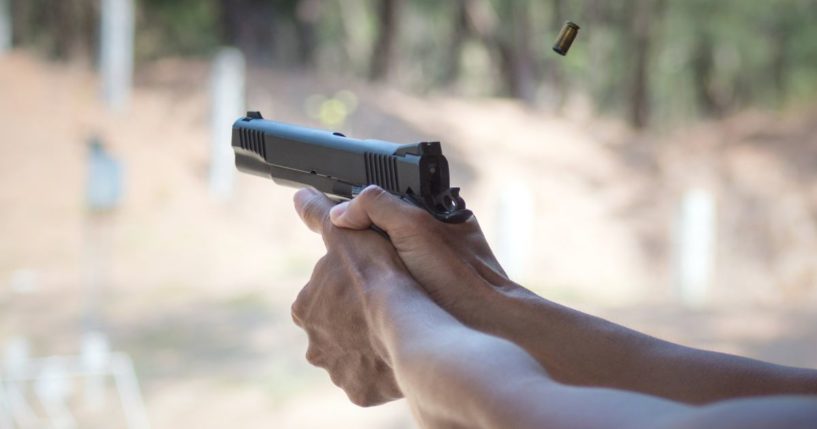 A man fires a handgun in this stock image.