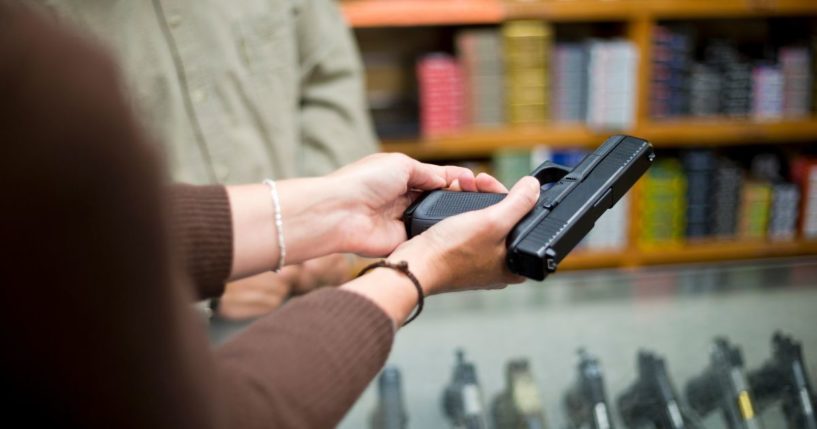 A woman holds a gun in this stock image.