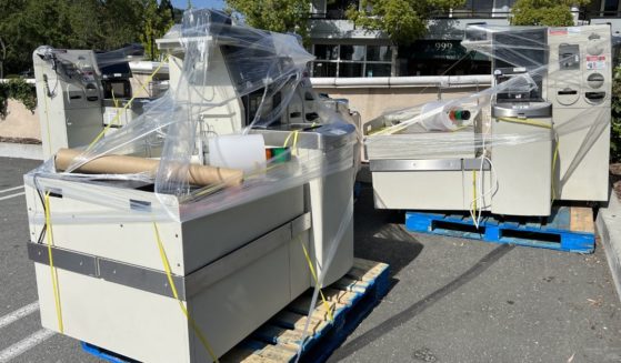 Several self checkout stations are wrapped in shrink wrap in the parking lot of a supermarket in Lafayette, California during self checkout station installation or removal, June, 2023.