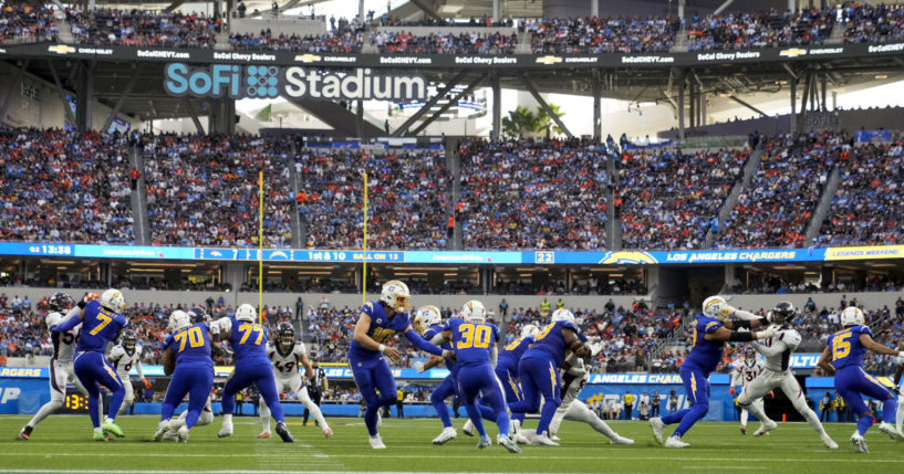 Los Angeles Chargers quarterback Justin Herbert hands the ball to running back Austin Ekeler during a game against the Denver Broncos on Dec. 10 in Inglewood, California.