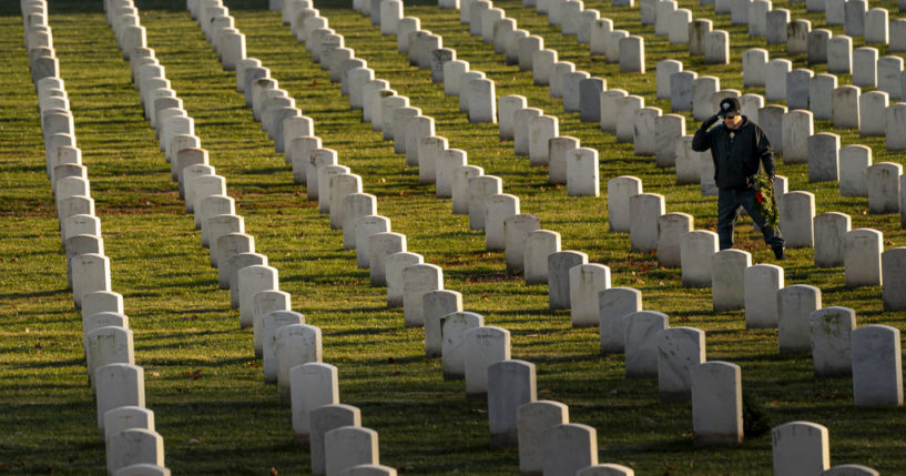 A man salutes after placing a wreath at Arlington National Cemetery during Wreaths Across America Day, Saturday, in Arlington, Virginia.