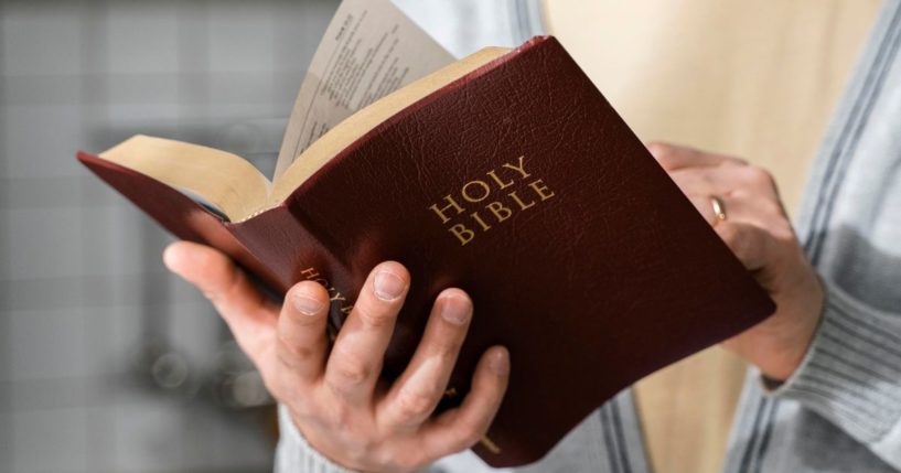 A woman reads the Bible in this stock image.