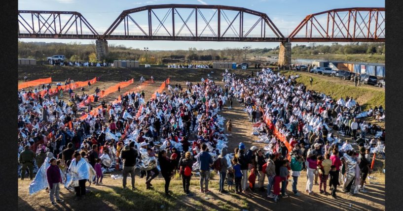 Thousands of immigrants, most wearing thermal blankets, await processing at a U.S. Border Patrol transit center on Tuesday in Eagle Pass, Texas. Major surges of migrants illegally crossing the Rio Grande have overwhelmed U.S. border authorities in recent weeks.