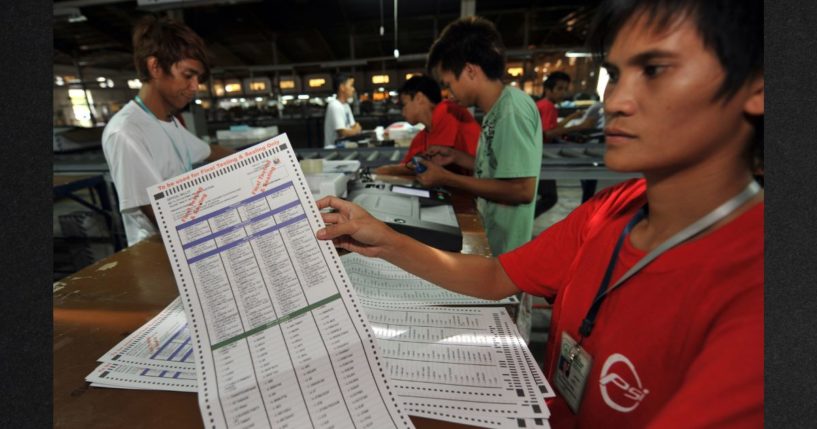 A Smartmatic employee shows a ballot paper after testing it on a election automated machines at the company's warehouse in Cabuyao town, Laguna province south of Manila on May 5, 2010. After 13 years, the Commission on Elections has disqualified Smartmatic Philppines Inc. from participting in its public bidding and procurement processes.