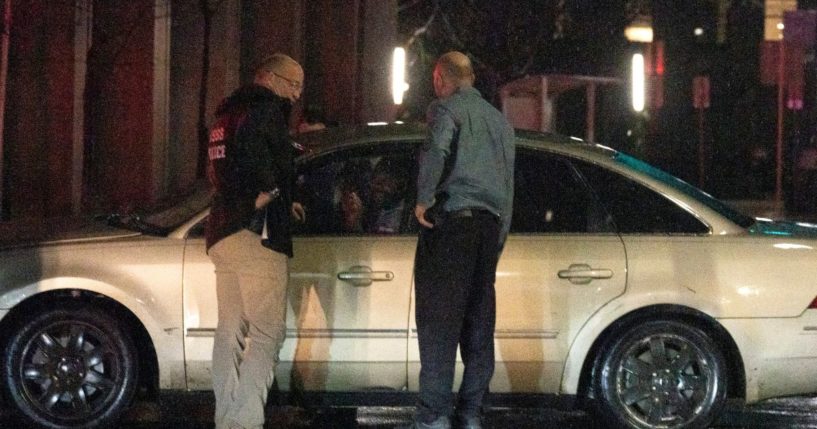 Secret Service Police, left, and security personnel question the driver of a vehicle that plowed into a parked SUV that was part of President Biden's motorcade Sunday night while the president was leaving a visit to his campaign headquarters in Wilmington, Delaware, on Sunday.