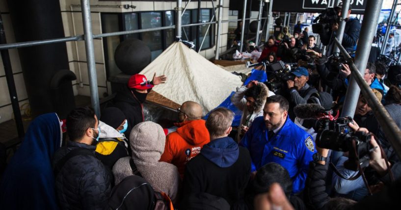 Migrants speak with NYC Homeless Outreach members as they camp out in front of the Watson Hotel after being evicted on Jan. 30 in New York City.