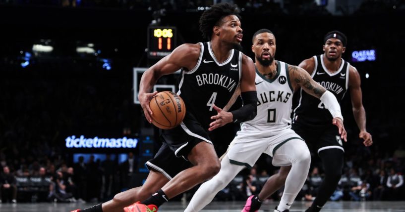 Dennis Smith Jr. of the Brooklyn Nets is defended by Damian Lillard of the Milwaukee Bucks during the third quarter of a game at Barclays Center on Dec. 27, 2023, in New York City.