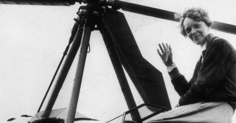 American aviator Amelia Earhart, the first woman to complete a solo transatlantic flight, waves as she emerges from the cockpit of a rotorcraft in Newark, New Jersey, in 1935.