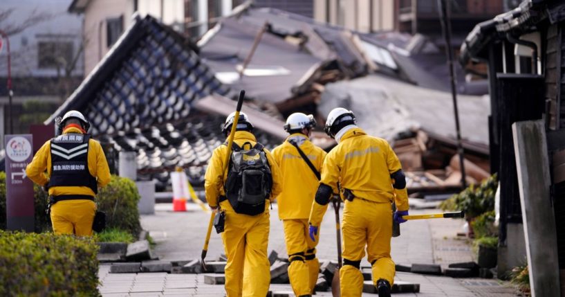 Firefighters patrol an area to check damaged houses Saturday in Wajima, northwest of Tokyo, following Monday's deadly earthquake.