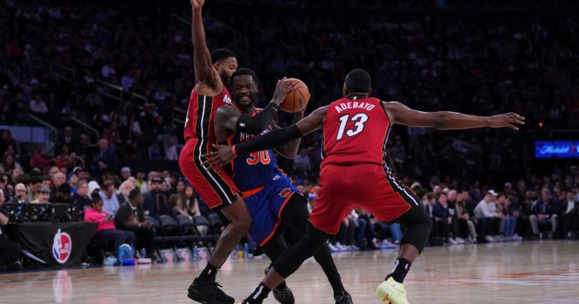 Julius Randle of the New York Knicks, center, drives to the basket against Haywood Highsmith, left, and Bam Adebayo, right, of the Miami Heat in the second half of Saturday's game in New York City.