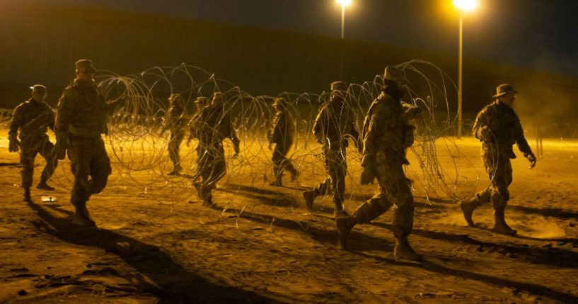 Texas National Guard soldiers carrying concertina wire