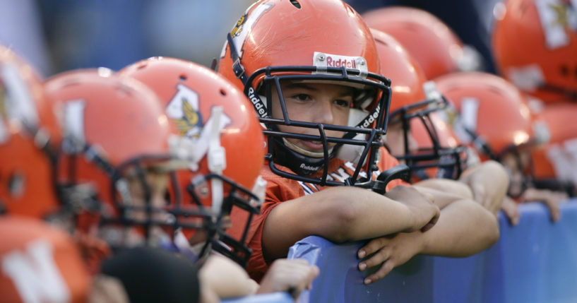 Pop Warner football players look on before an NFL pre-season game between the San Francisco 49ers and the San Diego Chargers in San Diego, California, on Sept. 4, 2009. The California Legislature is considering a bill that would ban children under the age of 12 from competing in tackle football in an effort to reduce brain injuries.