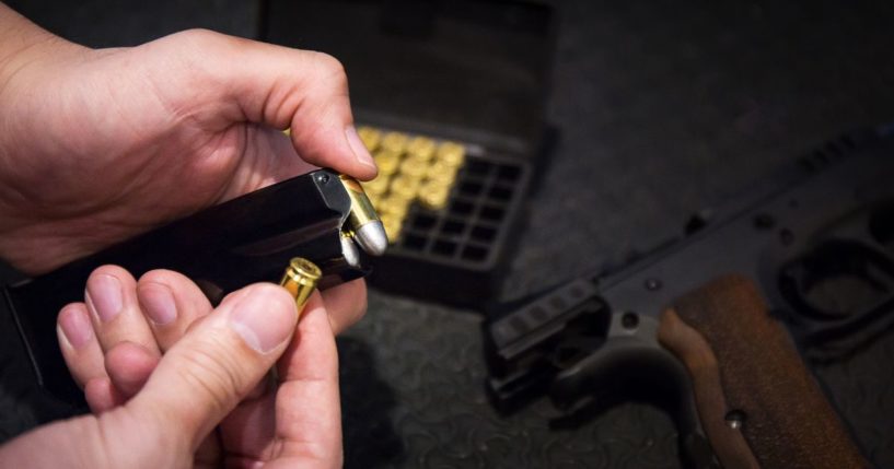 A man loads a gun in this stock image.