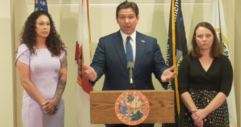 Florida Gov. Ron DeSantis is flanked by two of the late Jeffery Epstein's victims, Haley Robson, left, and Jena-Lisa Jones, after signing a bill Thursday into law that officially authorizes the release of documents from a grand jury investigation in Palm Beach County regarding Epstein's sexual assault of underage girls.