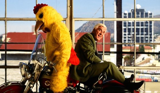 Actor Leslie Nielsen with a motorcycle and a man in a chicken suit in Hollywood, California, in 1992.