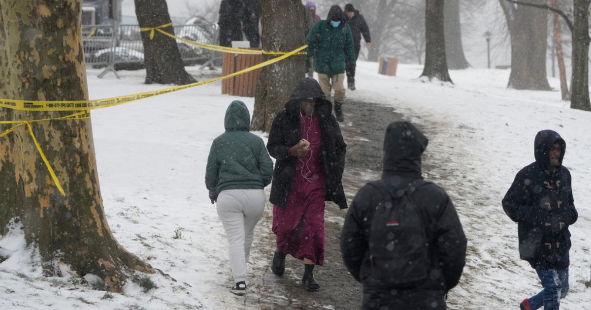 People walk through the snow to and from Manhattan at a temporary shelter for migrants on Randall's Island in New York, on Jan. 19.