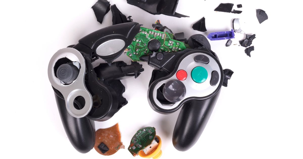 A broken video game controller displayed in front of a white background.