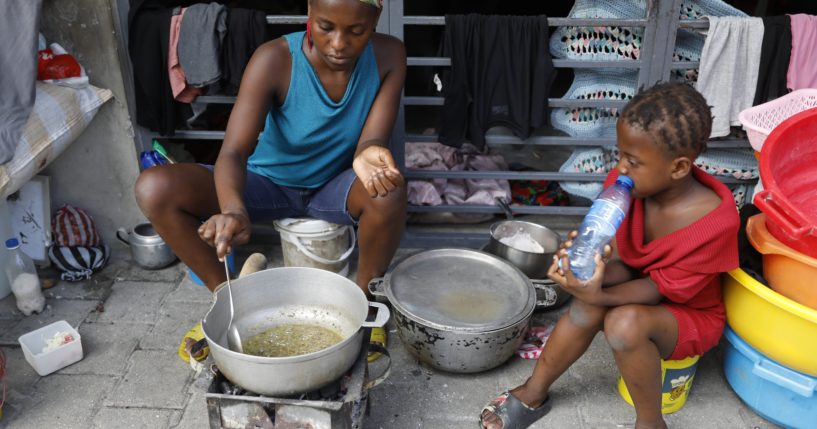 A woman cooks at a shelter for families displaced by gang violence in Port-au-Prince, Haiti, Friday.