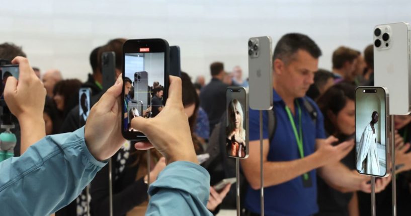 An attendee takes a picture of the new iPhone 15 Pro during an event at the Steve Jobs Theater at Apple Park on Sept. 12 in Cupertino, California.