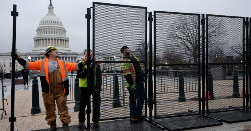 Eight-foot-tall steel fencing is put up around the U.S. Capitol in Washington on Wednesday, the day before President Joe Biden was to deliver the State of the Union address.