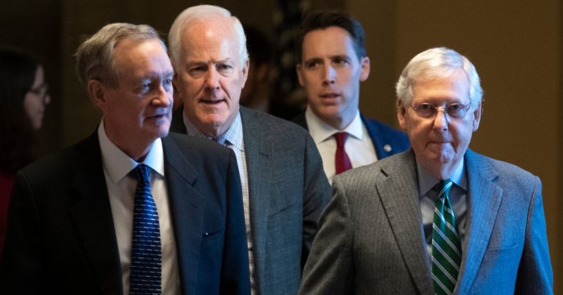 Sens. Josh Hawley, second from right, and Mitch McConnell, right, walk to the Senate chamber at the U.S. Capitol in 2020. Hawley and McConnell currently are at odds over the Radiation Exposure Compensation Act.