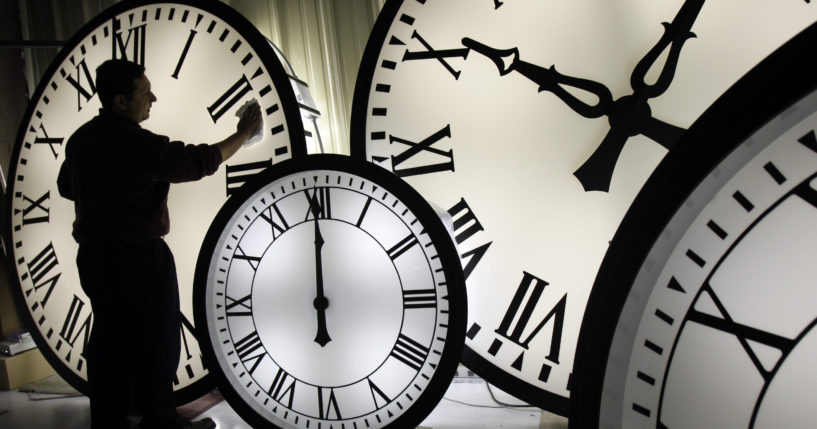 An Electric Time Co. employee cleans the face of an 84-inch Wegman clock at the plant in Medfield, Massachusetts, in 2008. Most Americans will set their clocks forward by one hour this weekend, to daylight saving time.