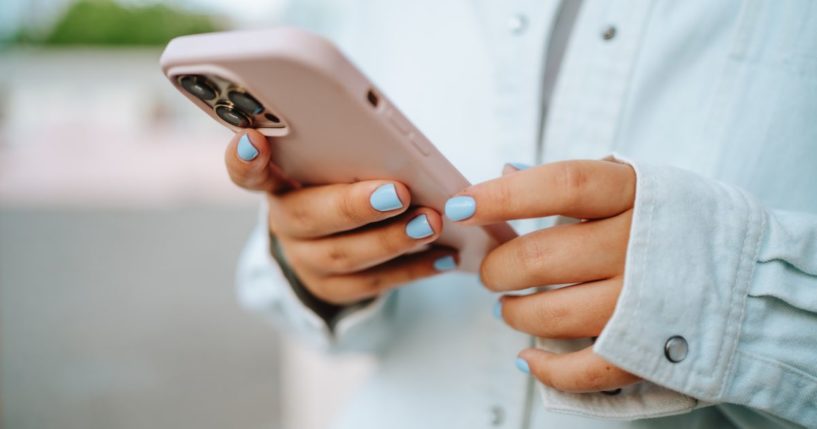 This stock image shows a girl using a cell phone.