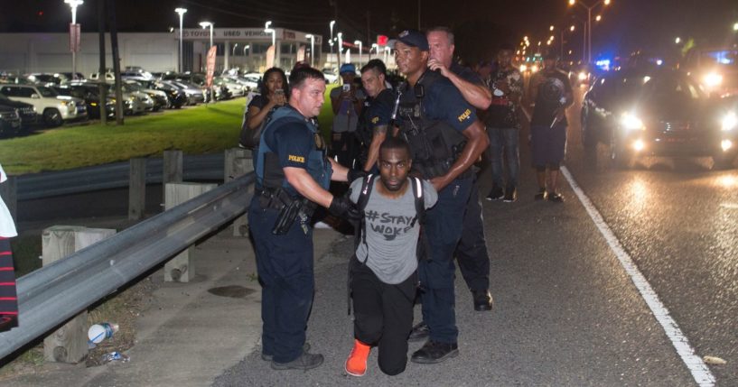 activist DeRay McKesson mugging for the camera while being arrested