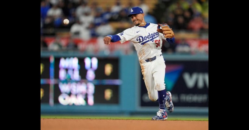 Los Angeles Dodgers shortstop Mookie Betts throws out San Diego Padres' Jackson Merrill at first base on a ground ball during the fourth inning of a baseball game Saturday in Los Angeles.