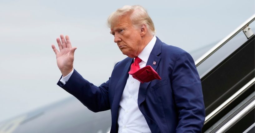 Donald Trump waving as he steps off his plane