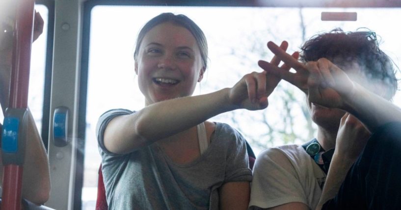 Climate activist Greta Thunberg flashes a V-sign after being detained and driven off in a bus after joining protestors who blocked a road during a climate protest by Extinction Rebellion and other activists in The Hague, Netherlands, Saturday.