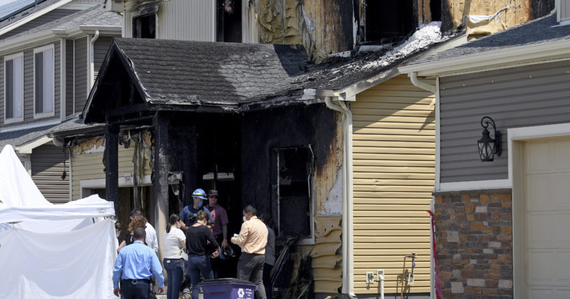 Investigators stand outside a house where five members of a Senegalese family were found dead after a fire in Denver on Aug. 5, 2020.