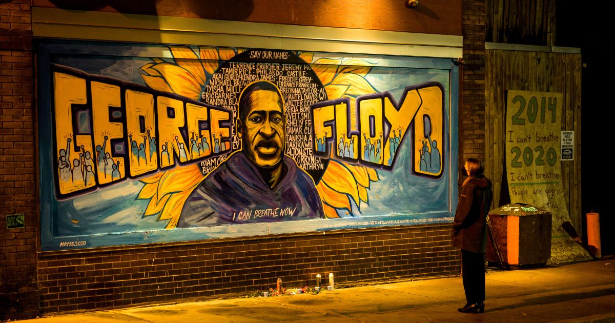 A woman looks at a mural on the wall of Cup Foods during a vigil for George Floyd in Minneapolis on May 25, 2022.