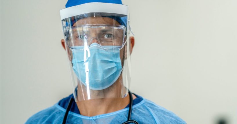 A medical professional is wearing full protective wear in a hospital setting.