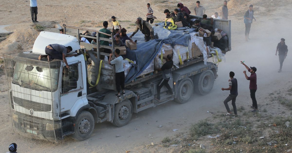 Palestinians rush trucks as they transport international humanitarian aid from the US-built Trident Pier in the central Gaza Strip on Saturday.