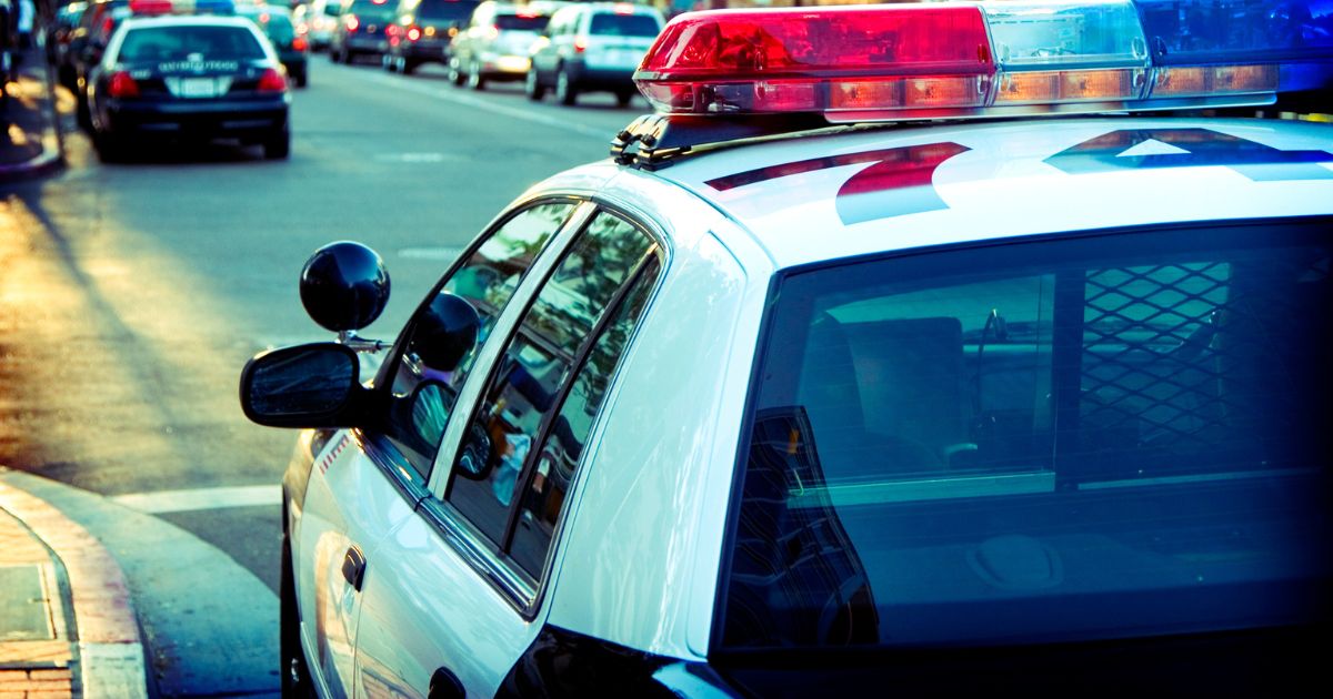 This stock image shows a police car parked on a city street.
