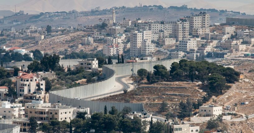 This image shows an overview into the West Bank and a view of the wall separating East Jerusalem as viewed from the Mount of Olives.